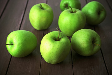 Green apples on wooden table, closeup