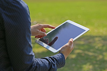 公園でタブレットを見る女性