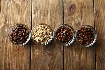 Coffee beans in saucers on wooden background