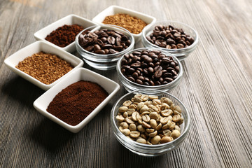 Coffee beans in saucers on wooden background