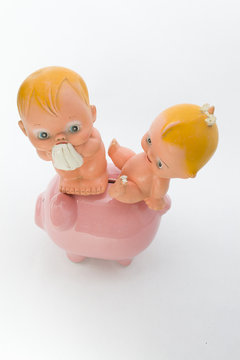 baby boy sitting on the floor with a piggy 
bank