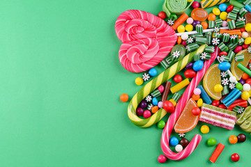 Colorful candies on green background