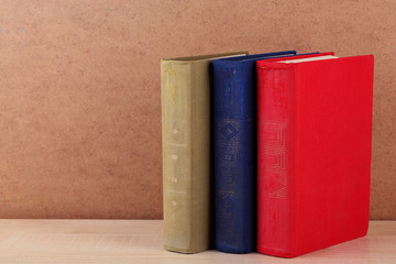 Books on shelf, close-up, on wooden background