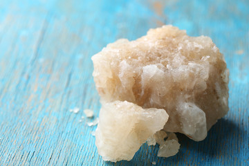 Crust of sea salt from Dead Sea coast, on color wooden background
