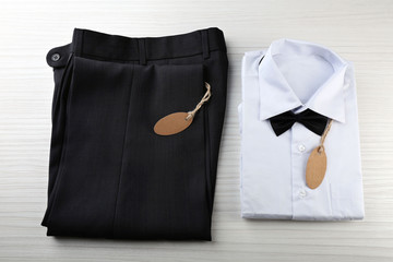 Price tag on white shirt, trousers on wooden background