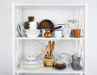 Kitchen shelving with dishes on white brick wall background