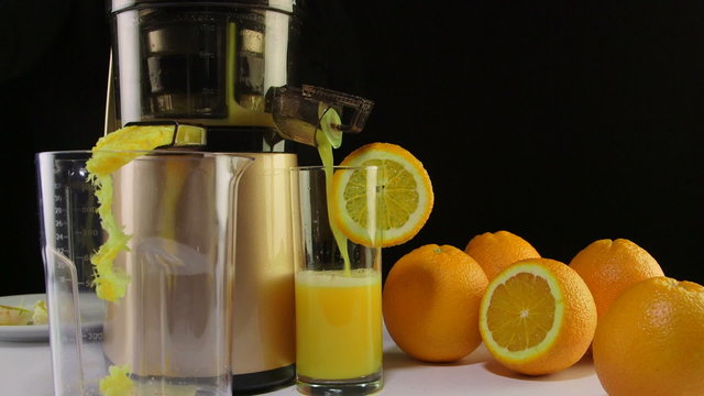 Making fresh fruit juice from orange using  cold press juicer