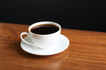 Cup of coffee on table on dark background