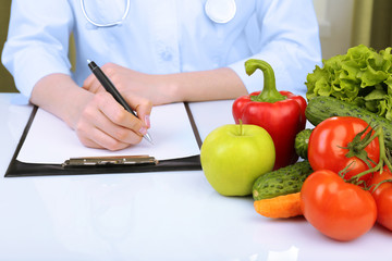 Nutritionist doctor writing  diet plan in office