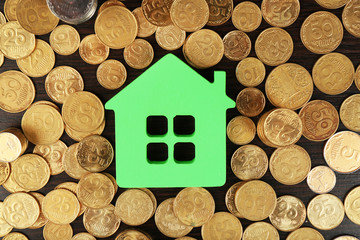 Model of house with pile of coins, closeup