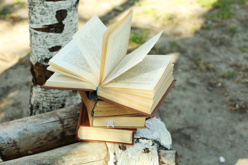 Stack of books on bench, outdoors