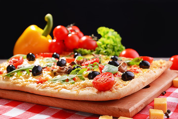 Delicious homemade pizza on table on black background