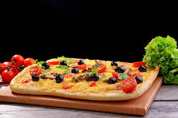 Delicious homemade pizza on table on black background