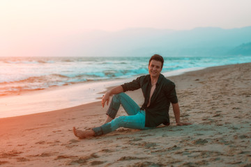 Handsome sexy and smiling man relaxing at beach.