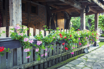 Fototapeta na wymiar Old house patio with flowers on wooden fence