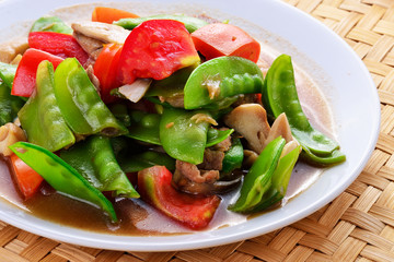 Stir fried snow peas and pork on plate