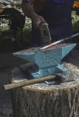 Blacksmith forges iron on anvil