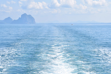 Ship track on the ocean with clouds in the background