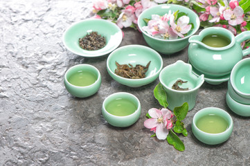 Teapot and cups with spring apple blossoms. Tea ceremony