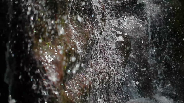 waterfall flowing down over rocky stones