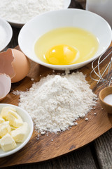 prepared baking ingredients on a wooden board, top view
