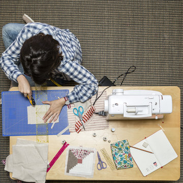 Young girl making hand bags and accessories at home, top view