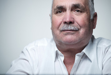 Close-up portrait of a Caucasian senior man with mustache