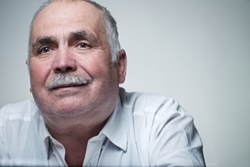 Close-up portrait of a Caucasian senior man with mustache