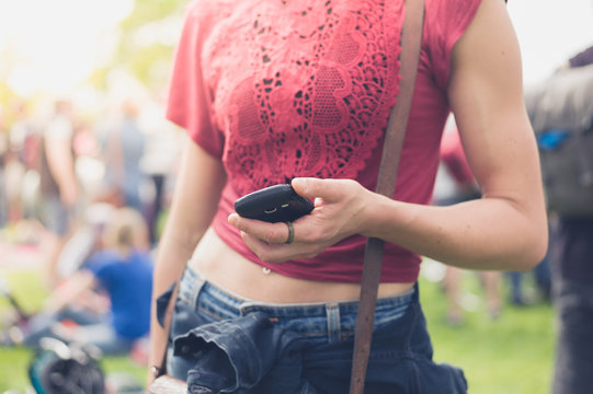 Young woman using smartphone at festival