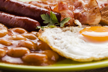 Full english breakfast with bacon, sausage, fried egg, baked bea