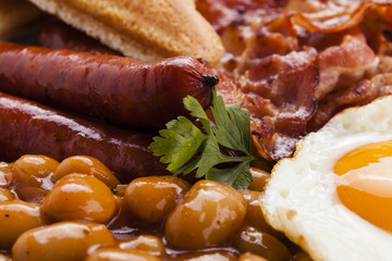 Full english breakfast with bacon, sausage, fried egg, baked bea