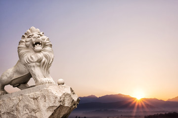 Fototapeta na wymiar lion statue with landscape at sunrise