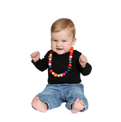 smiling baby sits with colorful handmade wooden necklaces