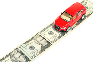 Red toy car on money road isolated on white background.