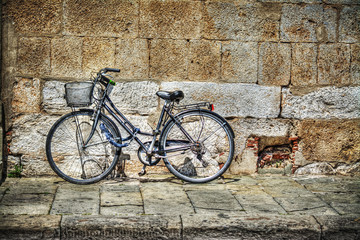 bicycle against a rustic wall in Tuscany