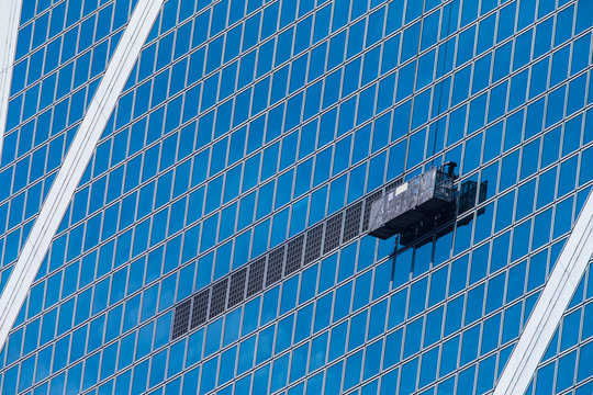 Suspended working platforms on blue building