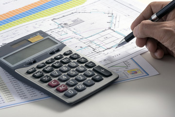 Businessman hand holding pen on blueprint