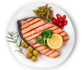 White plate of salmon steak with vegetables.
