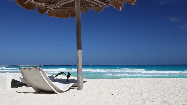 Caribbean beach with grass umbrellas and beds