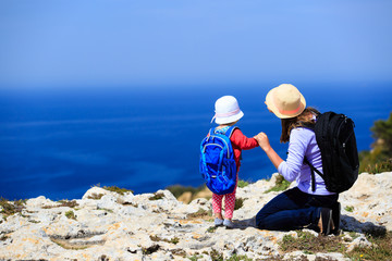 mother with little daughter travel in mountains
