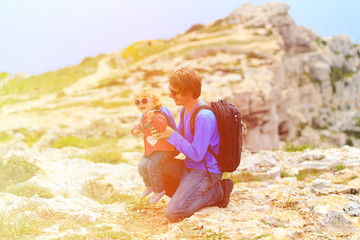 father and little daughter hiking in mountains