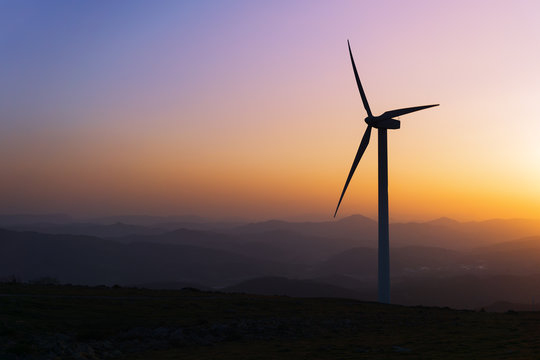 wind turbine silhouette on mountain at sunset