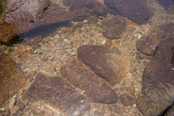 Klares Wasser im Bergsee mit Steinen