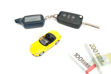 yellow car, keys and money on white