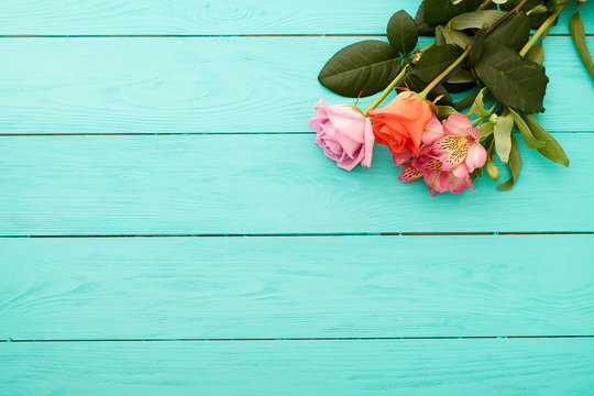 Flowers with copy space on blue wooden background. Top view