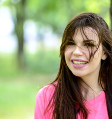 Portrait close up of young beautiful smiling woman in nature