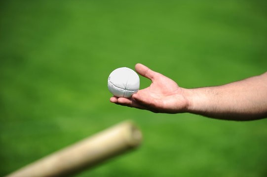 Hand holding a rounders ball