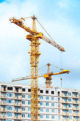 Fototapeta na wymiar Two cranes work in modern houses massive