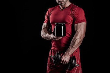 beautiful young athletic man holding a jar of sports nutrition
