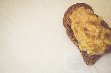 crisp bread with jam on a light color wood background- directly above view
